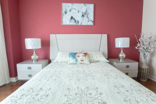 a bedroom with a white bed with red walls at Main Floor Luxury Apartment in Vaughan