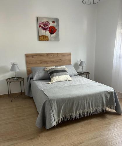 ein Schlafzimmer mit einem Bett und zwei Tischen mit Lampen in der Unterkunft Bajo casa en Moaña in Moaña