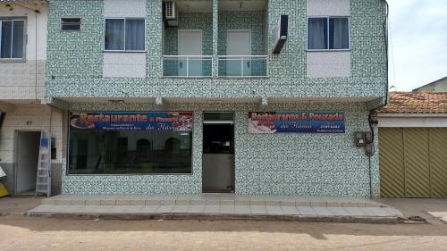 a building with a sign on the side of it at Pousada do Flávio in Barra de Itabapoana