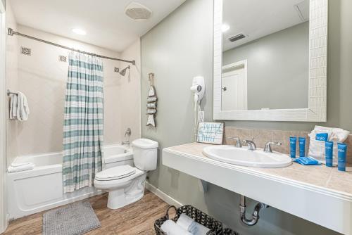a bathroom with a sink and a toilet and a mirror at Luau II 6429 in Destin