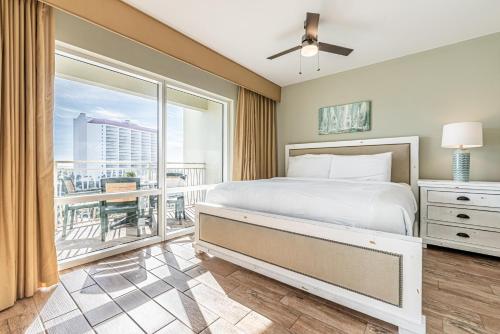 a bedroom with a bed and a balcony at Luau II 6429 in Destin