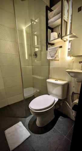 a bathroom with a toilet and a shower and a sink at Red Skillet in Lagos