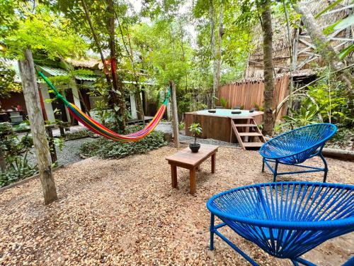 a patio with two blue chairs and a hammock at VILA AMZ, 3 minutos da Praia do Lago! in Alter do Chao
