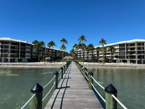 a wooden bridge over the water with palm trees and buildings at Beacon Reef Condo Oceanside in Islamorada