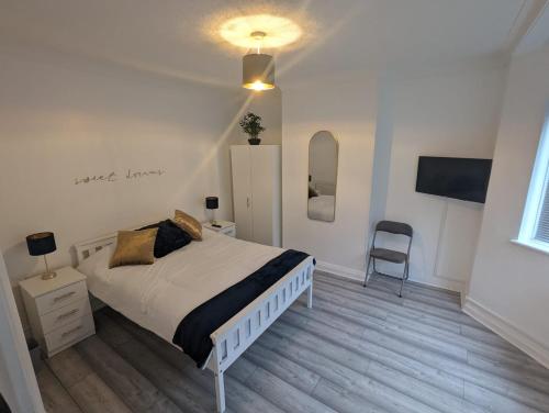 a bedroom with a bed and a desk and a chair at The Manor Guest House in Wembley in London