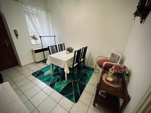 une salle à manger avec une table et des chaises blanches dans l'établissement Tabán Apartman, à Pécs