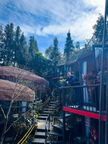 a woman sitting on a balcony of a train at Plum Homestay in Dồng Văn