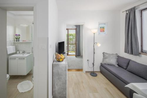 ein Wohnzimmer mit einem Sofa und einer Küche in der Unterkunft Apartments Katana in Poreč