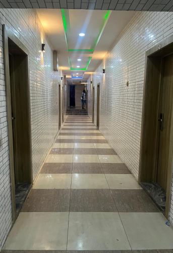 un lungo corridoio con una persona che cammina lungo il corridoio di EXCLUSIVE MANSION HOTELS a Lagos