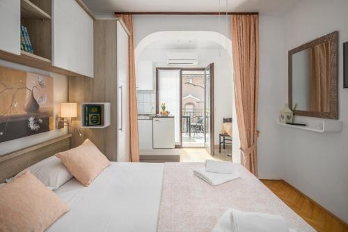 ein Schlafzimmer mit einem großen weißen Bett in einem Zimmer in der Unterkunft Apartments Katana in Poreč