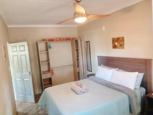1 dormitorio con 1 cama con 2 toallas en Comfortable cottage in Big 5 Game Reserve en Dinokeng Game Reserve