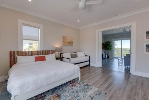 a bedroom with a white bed and a living room at Spindrift House -Huge Pool, Dock in Stock Island