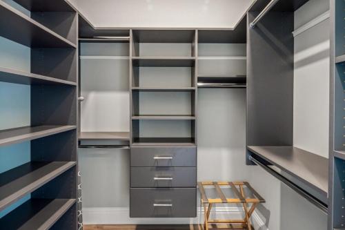 a walk in closet with black shelves and a wooden stool at Spindrift House -Huge Pool, Dock in Stock Island