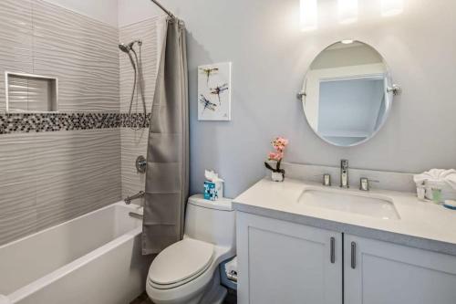 a bathroom with a sink and a toilet and a mirror at Spindrift House -Huge Pool, Dock in Stock Island