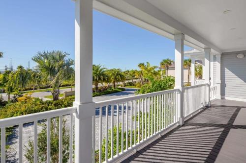 a balcony with a view of the beach and palm trees at Spindrift House -Huge Pool, Dock in Stock Island