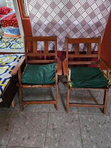 dos sillas de madera sentadas una al lado de la otra en una habitación en YAA HOMÉ, en Palimé