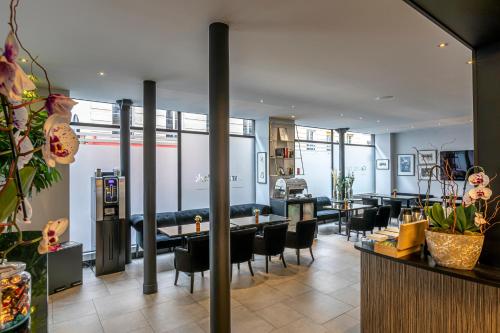 un restaurant avec des tables et des chaises dans une salle dans l'établissement Gardette Park Hotel, à Paris