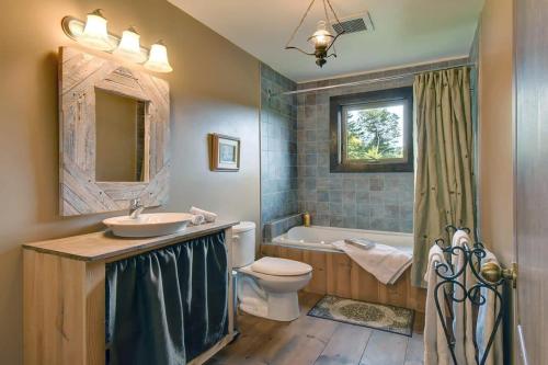 ein Badezimmer mit einem Waschbecken, einem WC und einer Badewanne in der Unterkunft Front RIVER private BEACH 2 HOT TUBS 15 p SAUNA in Labelle