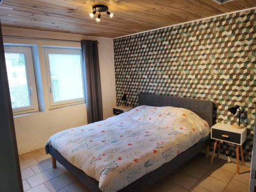 a bedroom with a bed and a brick wall at le nid du calice in Abreschviller