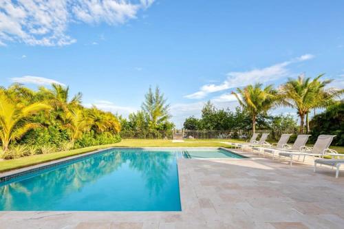 a swimming pool with chairs and palm trees at Mirador House -Pool & Dock! in Stock Island