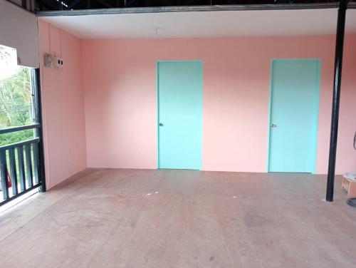 Villa Travellers House في موالبوال: غرفة فارغة بجدران وردية وأبواب زرقاء