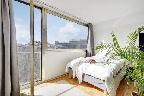 a bedroom with a bed and a large window at VICTOR HUGO - ARC de TRIOMPHE - TROCADERO in Paris