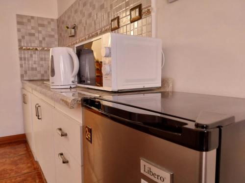 uma cozinha com um micro-ondas em cima de um frigorífico em Killary Apart Hotel em Antofagasta