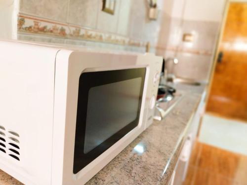 a microwave oven sitting on a counter in a kitchen at Killary Apart Hotel in Antofagasta
