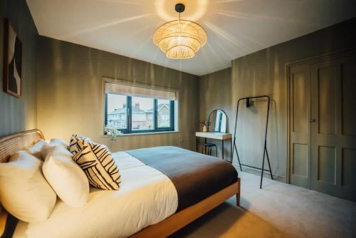 ein Schlafzimmer mit einem Bett mit Kissen und einem Fenster in der Unterkunft Regent's Retreat - Stunning home in Middlesbrough in Middlesbrough