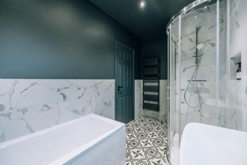 Das Bad ist mit einer Badewanne und einer Glasdusche ausgestattet. in der Unterkunft Regent's Retreat - Stunning home in Middlesbrough in Middlesbrough