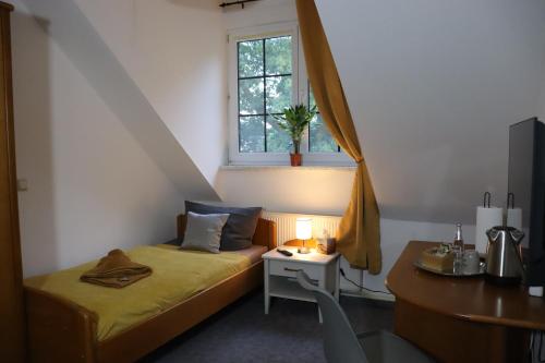 Kleines Zimmer mit einem Bett und einem Fenster in der Unterkunft Pension Lausitzer Seenland in Elsterheide