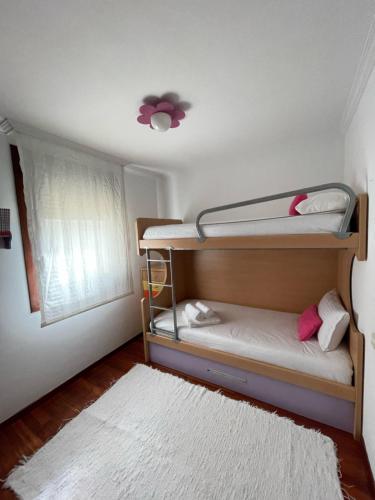 um quarto com 2 beliches e um tapete branco em Apartamento Hío Aldán - Cangas em Vilariño