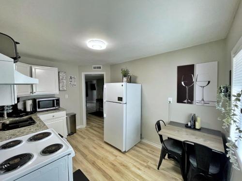 a kitchen with a white refrigerator and a table at *NEW* The Cozy Haven, 5 minutes to ATL airport in Atlanta
