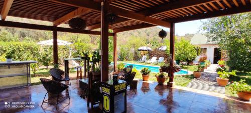 a covered patio with chairs and a swimming pool at Tiny House - Oasis de tranquilidad, belleza y seguridad in Los Barriales