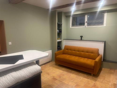 - un canapé brun dans une chambre avec fenêtre dans l'établissement Studio 1 rue des Epinaux, à Aix-en-Provence