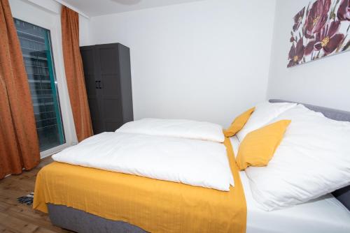 a bedroom with a bed with yellow and white pillows at Lipi Apartment in Vienna