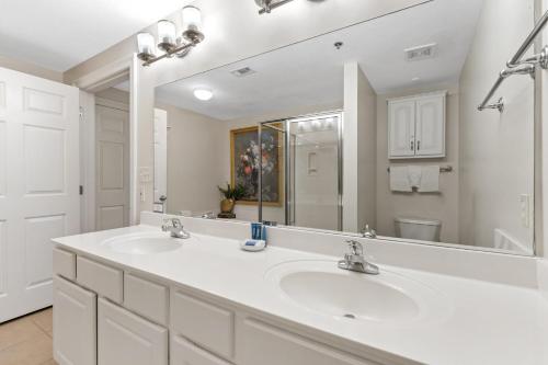 a white bathroom with two sinks and a large mirror at Ariel Dunes II 602 in Destin