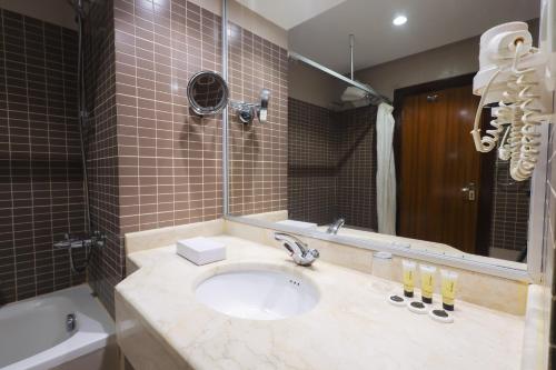 a bathroom with a sink and a mirror at فندق البراق الماسي in Al Khansāk