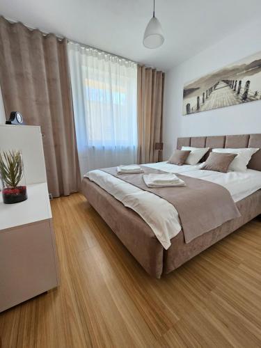 a bedroom with a large bed and a table at Apartament na Orlej w Zamościu in Zamość
