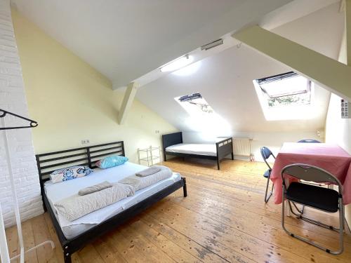 a bedroom with a bed and a table in a room at Schöpfwerk Hostel in Vienna