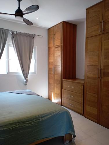 Schlafzimmer mit Holzschränken und einem Bett in der Unterkunft Appartement 1 CH centre Las Terrenas 100 m2 piscine et parking in Las Terrenas