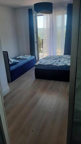 1 Schlafzimmer mit 2 Betten und einem Balkon mit Aussicht in der Unterkunft Widokowy Zakątek in Czorsztyn