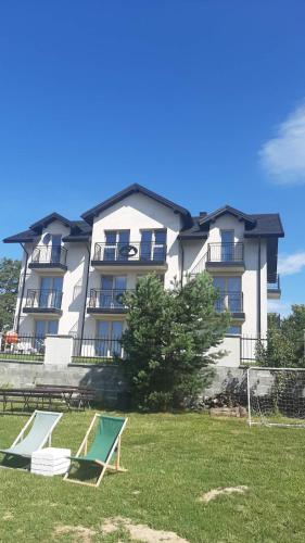 a large building with two lawn chairs in front of it at Widokowy Zakątek in Czorsztyn