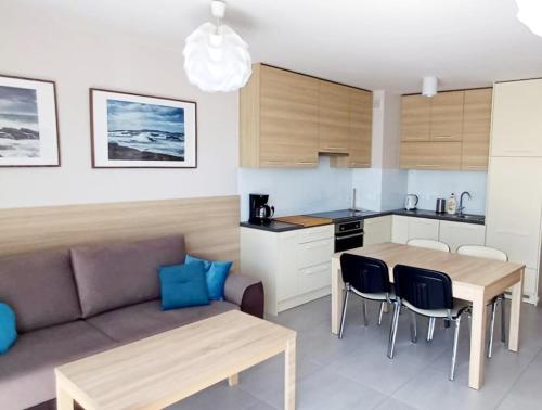 里沃Apartament Zachodni Rewal的一间厨房和一间带沙发和桌子的客厅