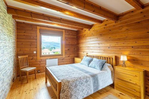 ein Schlafzimmer mit einem Bett in einer Holzhütte in der Unterkunft Quinta Alvaredo in Melgaço