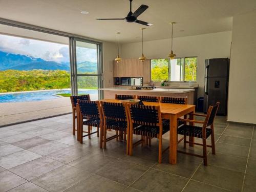 a kitchen with a wooden table and chairs with a view at Finca Luz de Luna in Santa Fe de Antioquia