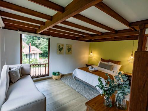 um quarto com uma cama e um sofá em Chalet Andino Sesquile em Suesca