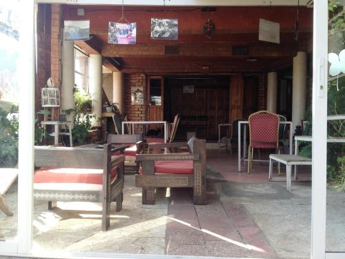 a porch with benches and chairs on a patio at Le Karthala Chambres D'Hotes in Antananarivo
