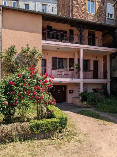 un edificio de apartamentos con rosas rojas delante de él en Aventures modernes, en Roanne