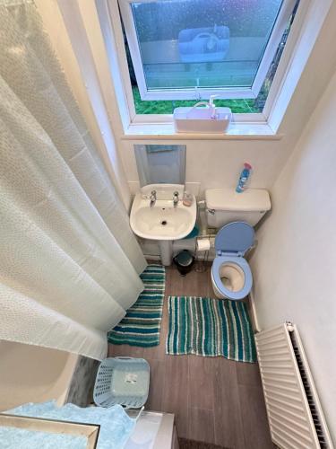 een kleine badkamer met een wastafel en een raam bij Come n Go - Homestay in Birmingham
